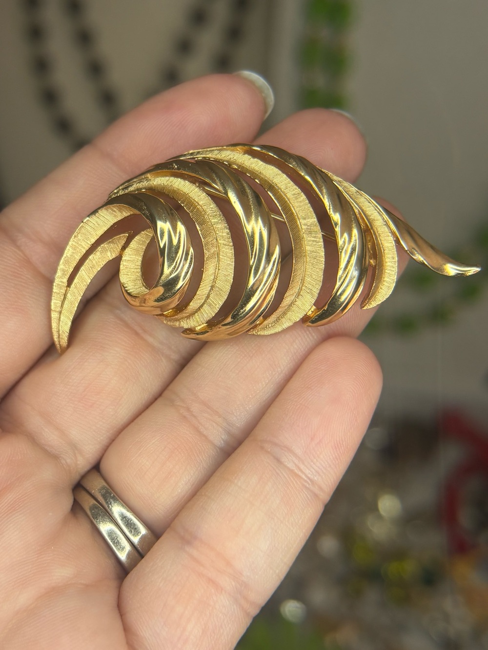 Vintage Trifari gold-tone statement brooch featuring a bold sculptural swirl des
